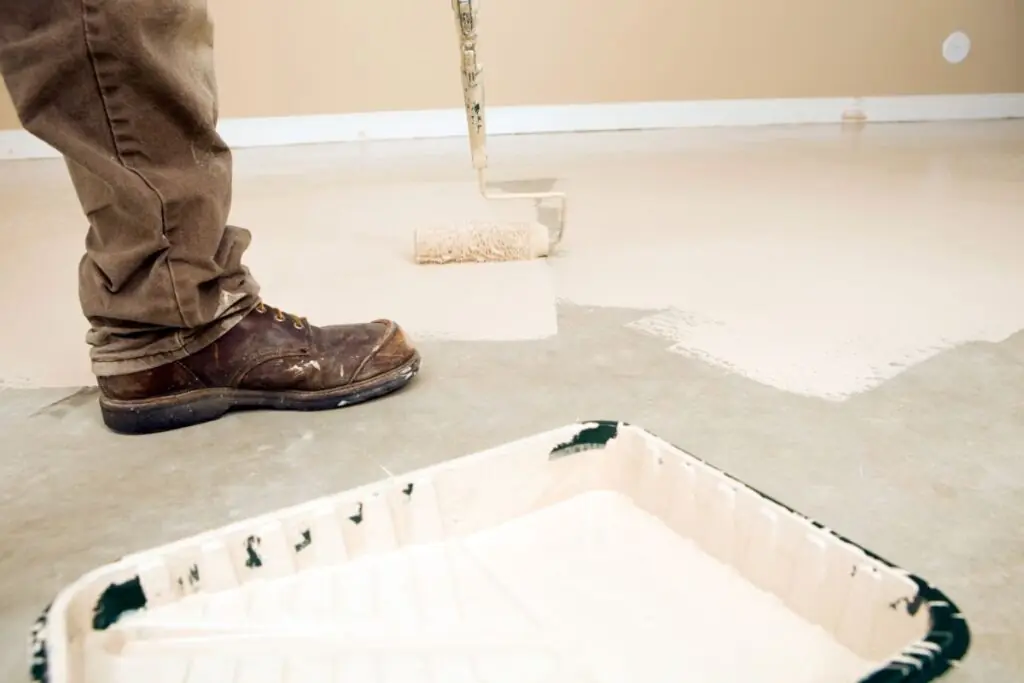 painter rolling epoxy paint on concrete floors