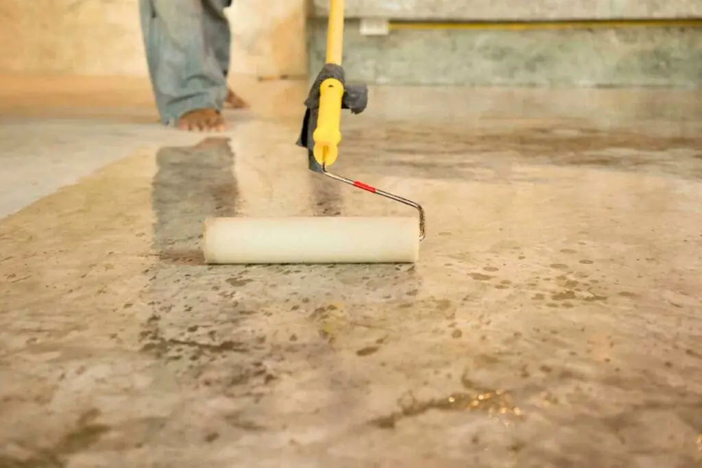 a man staining concrete floors