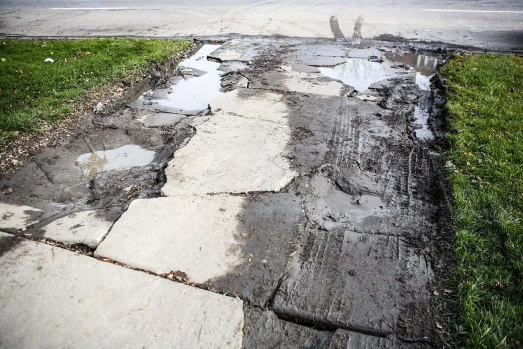 broken damage concrete driveway with puddles